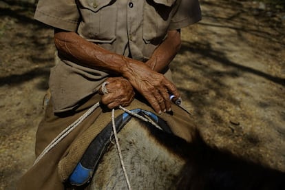 As terras foram concedidas gratuitamente aos agricultores, trabalhadores agrícolas e meeiros. Muitos agricultores se juntaram para trabalhar sob o guarda-chuva do Estado e em fazendas cooperativas. Na foto, Hipolito Marrero, de 83 anos, fuma charuto enquanto monta um cavalo nas montanhas próximas à cidade de Santo Domingo (Cuba).