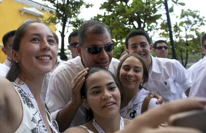 Ecuador's President Rafael Correa, center top, poses for pictures with youth as he arrives to attend a Mass as part of peace ceremony events in Cartagena, Colombia, Monday, Sept. 26, 2016. On Monday Colombia's government and the Revolutionary Armed Forces of Colombia (FARC) will sign a peace agreement in Cartagena to end over 50 years of conflict.  (AP Photo/Ariana Cubillos)