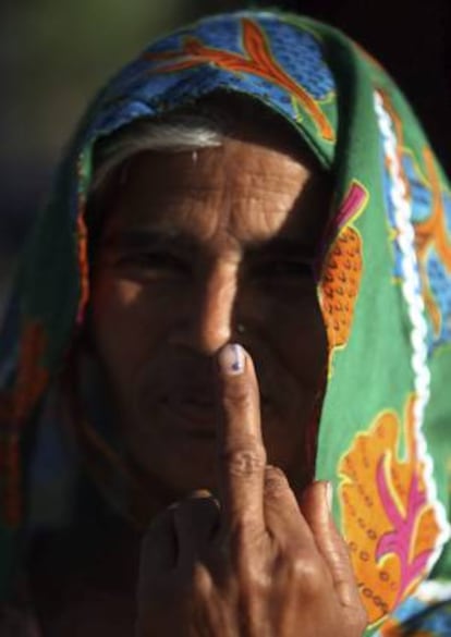 Una mujer muestra su dedo con la marca que indica que ya ha ejercido su derecho al voto en un colegio electoral en la localidad de Tiagon (India). EFE/Archivo