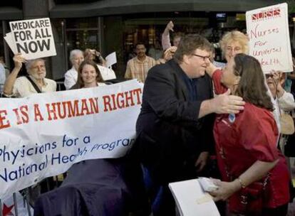 Michael Moore saluda a una simpatizante en la premiere de su última película documental.