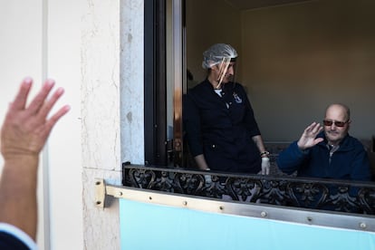 Un hombre saluda a un familiar desde la ventana de una residencia de la ciudad portuguesa de Figueira da Foz.