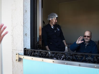 Un hombre saluda a un familiar desde la ventana de una residencia de la ciudad portuguesa de Figueira da Foz.