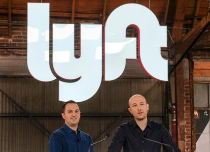 Lyft co-founders John Zimmer, left, and Logan Green speak before they ring a ceremonial opening bell in Los Angeles on March 29, 2019.