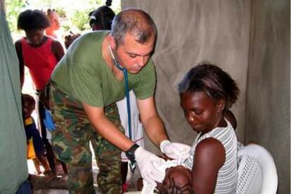 El capitán médico del Ejército español Juan Plaza atiende a una niña en la localidad haitiana de Fort Liberté.