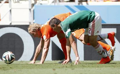 El jugador holandés Dirk Kuyt (i) y el mexicano Paul Aguilar intentan controlar el esférico