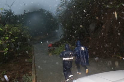 Policías municipales patrullan las calles de Huatulco bajo la lluvia del huracán, en el Estado de Oaxaca, México.