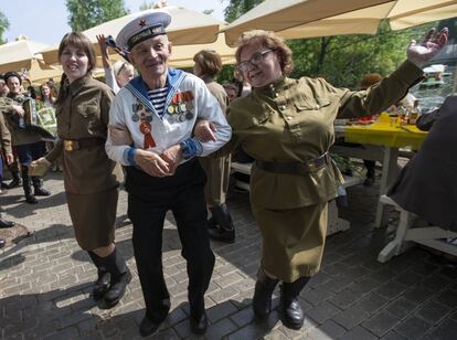 El veterano ruso Victor Novopashin, de 87 años, baila con dos mujeres vestidas con el uniforme de la era soviética, mientras celebran 74 años desde la victoria en la Segunda Guerra Mundial en el Parque Gorky en Moscú (Rusia).