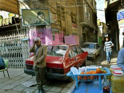 El retrato de Sadam Husein, sobre una esquina, preside una escena cotidiana en una calle de Bagdad el pasado viernes.