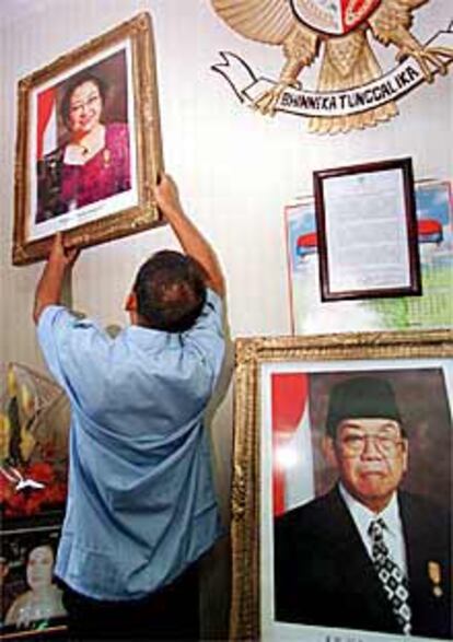 Un funcionario cuelga un retrato de Megawati tras retirar el de Wahid.
