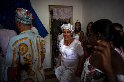 Maritza de la Rosa Perdomo, center, dances before a blue altar during a Santería ceremony in Havana, Cuba, Sunday, Nov. 13, 2022