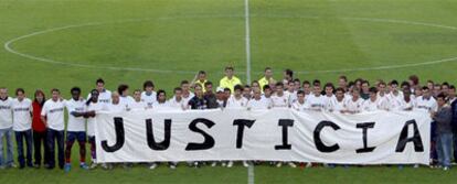 Los jugadores del Levante y del Valencia posan el domingo con una pancarta alusiva a los problemas económicos de los primeros.