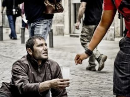 Un turista da limosna a un mendigo en Madrid.