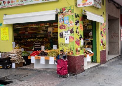 Un niño en la puerta de una frutería en la calle Francisco Madariaga, en la zona básica de salud Doctor Cirajas, una de las 37 afectadas por las restricciones de movilidad.