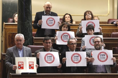 Los diputados de IU llevaron a la sesión de control su apoyo a la huelga general del 29-M contra la reforma laboral del Gobierno del PP, mostrando estos carteles. La ministra de Empleo, Fátima Báñez, les acusó de "hacer lo fácil" sobre la huelga, que es "esconderse tras las pancartas".