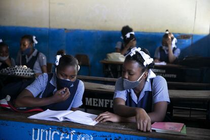 Estudiantes leen en la escuela Lycee Marie Jeanne en su primer día de regreso a clases en Puerto Príncipe, Haití, el lunes 17 de agosto. Después de cinco meses de cierre, las escuelas reabrieron exigiendo a los estudiantes que usen cubrebocas y dividiéndolos en grupos más pequeños con diferentes horarios.