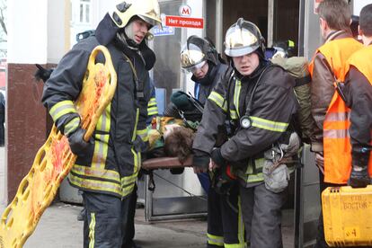 Bomberos evacuan a una mujer herida en el interior de Park Kulturi.