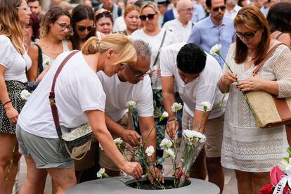 Familiares y víctimas de los atentados en La Rambla participan en una ofrenda floral durante los actos conmemorativos, este miércoles en Barcelona. Un reducido grupo de personas ha roto el minuto de silencio con gritos llamando a conocer “la verdad” sobre la matanza y con proclamas independentistas.