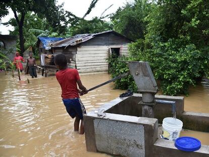 Un niño extrayendo agua en zona inundada luego del Huracán Matthew, en Haití.