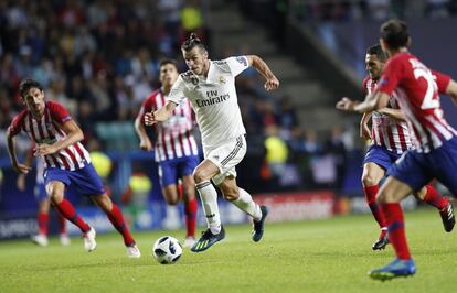 El jugador del Real Madrid Gareth Bale controla el balón ante jugadores del Atlético.