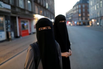 Sabina y Alaa, vestida con'niqab', se disponen para cruzar una calle en Copenhague (Dinamarca), el 30 de julio.