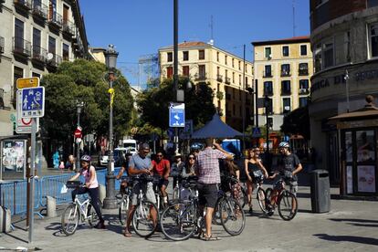 Varios turistas en bici en la esquina de la plaza de Lavapiés con la calle Argumosa.