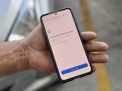 Una persona sostiene un teléfono que muestra la restricción de acceso a un sitio web de un medio de comunicación nicaragüense.