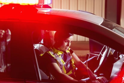 Una polic&iacute;a, en el interior de un coche patrulla.