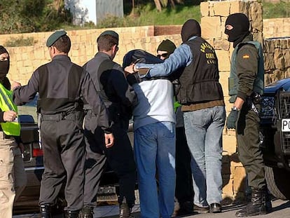 Guardias civiles rodean a uno de los detenidos antes de iniciar un registro en Estepona.