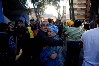La gente se abraza en la calle de Ciudad de México a la espera de noticias.