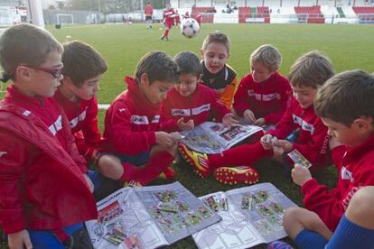 Un grupo de chavales de as categorías inferiores del Alondra pegan sus cromos.