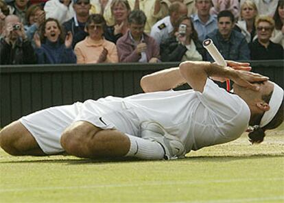 Roger Federer, tirado sobre la hierba tras ganar el título.