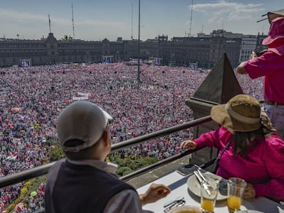 Personas miran la manifestación a favor del INE en la plancha del Zócalo desde una terraza, el 26 de febrero.