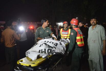 Els serveis d'emergència traslladen el cos d'una de les víctimes.