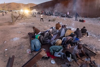 Un grupo de migrantes de países de Áfirca occidental rezan junto al muro fronterizo que divide Sonoyta, en el Estado mexicano de Sonora, y Lukeville, en Arizona, el pasado 6 de diciembre. 