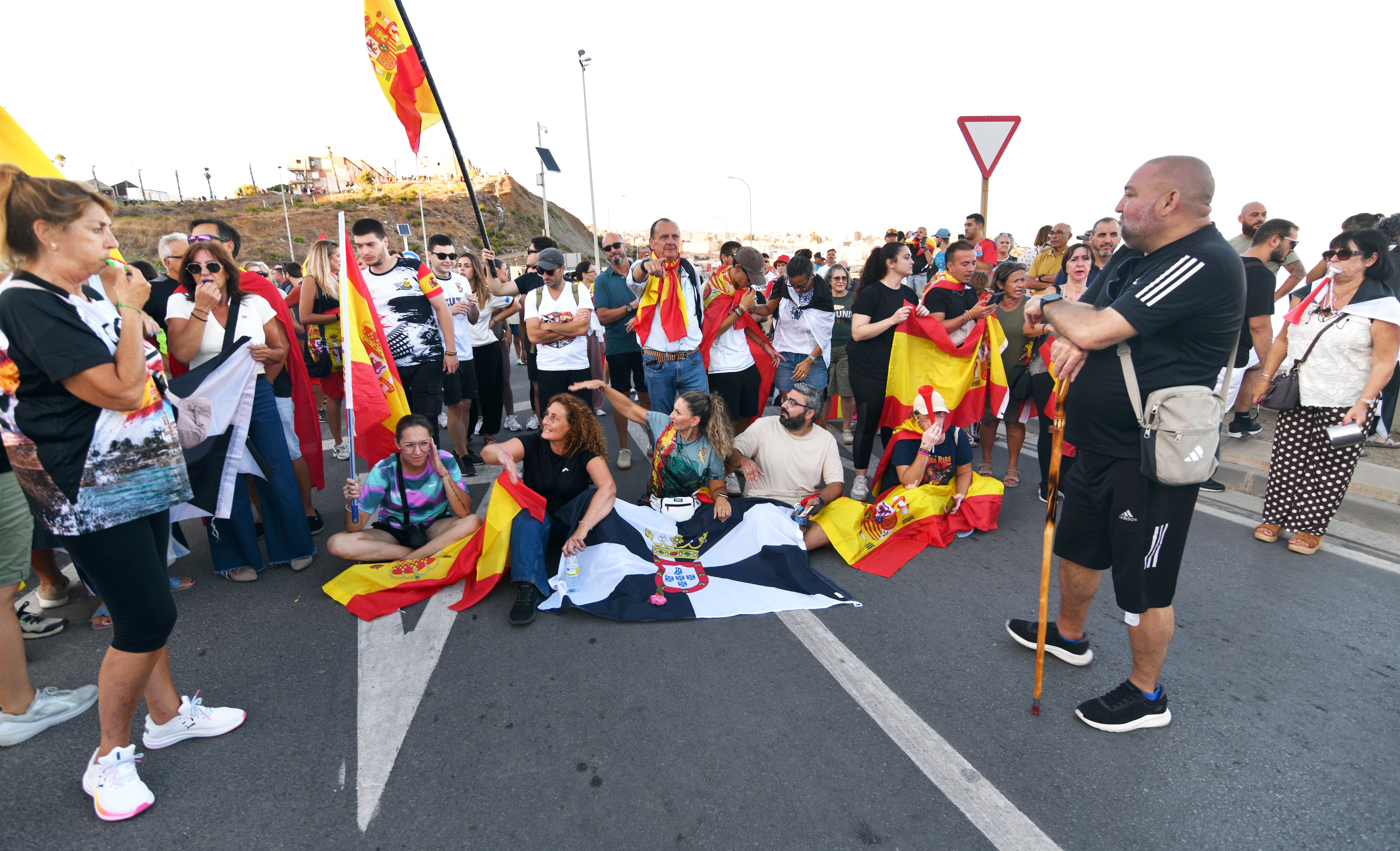A la derecha, apoyado en un bastón, Rafael García, presidente de la asociación de vecinos Loma Colmenar, participa en una concentración para reclamar la expulsión de los migrantes que llegaron a la ciudad a finales de mes, este sábado.