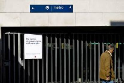 Un hombre camina junto a un cartel de metro que informa sobre una jornada de huelga en Lisboa (Portugal). EFE/Archivo