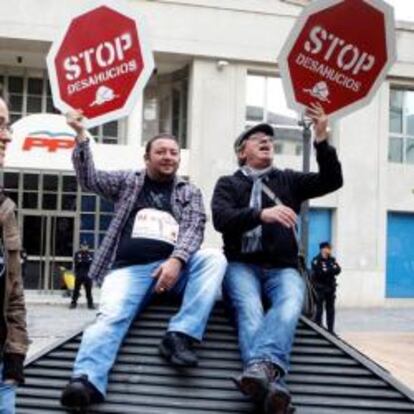 Varias personas protestan contra los desahucios frente a la sede del PP en Valencia