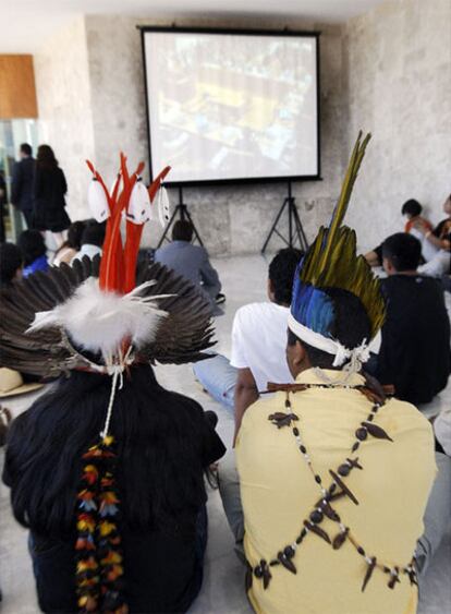 Indios de Raposa siguen en un monitor la sesión del Supremo.