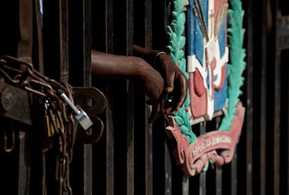 Un hombre se apoya en el portón cerrado que separa la frontera entre Haití y la República Dominicana, hoy en Jimaní (República Dominicana). La República Dominicana, país que comparte isla con Haití, también condenó el asesinato y reaccionó cerrando su frontera terrestre y prohibiendo todos los vuelos, menos aquellos destinados a evacuar al personal diplomático nacional o extranjero, así como a los ciudadanos dominicanos en el país vecino.