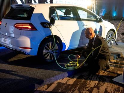 Un trabajador carga un Volkswagen Golf. 