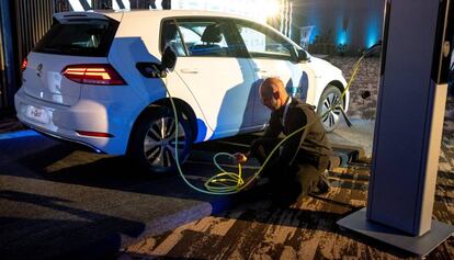 Un trabajador carga un Volkswagen Golf.