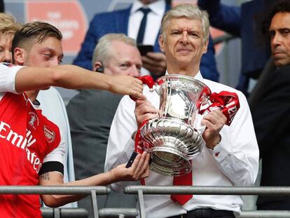 Mesut &Ouml;zil le entrega el trofeo a Ars&egrave;ne Wenger.