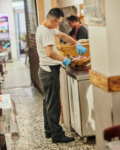  Axín corta con maestría uno de los productos favoritos de sus clientes, jamón ibérico, en Casa Axín. 