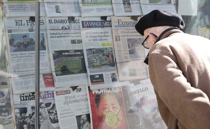 Un hombre observa los diarios con noticias sobre el coronavirus en un kiosko de periódicos de San Sebastián.