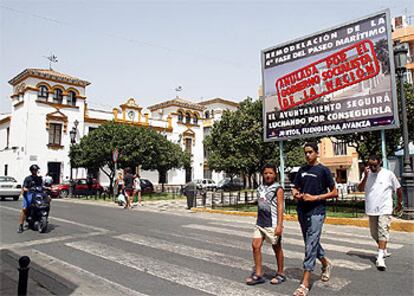 Vecinos de Fuengirola, junto a uno de los carteles-protesta colocados por el Ayuntamiento.