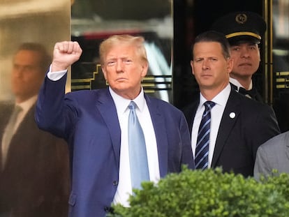 Former President Donald Trump, left, gestures as he leaves Trump Tower in New York, on April 13, 2023.