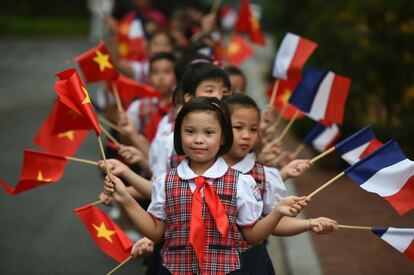 Niños ondean banderas de Francia y Vietnam durante una ceremonia de bienvenida al presidente francés François Hollande, en el Palacio Presidencial de Hanoi (Vietnam).