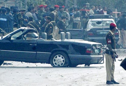 Soldados paquistaníes vigilan el coche del presidente Musharraf tras el intento de asesinato en Rawalpindi.