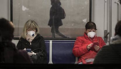 Dos mujeres con mascarilla en el metro de Barcelona.