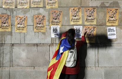 Un joven pega carteles en Barcelona para pedir la libertad de los ocho exconsellers encarcelados 